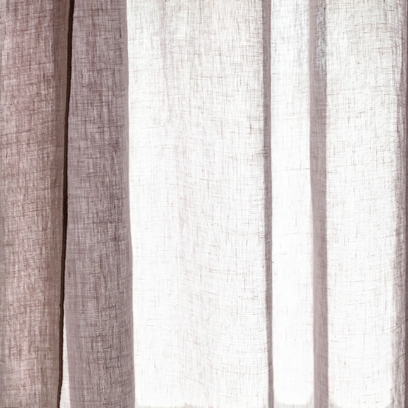 Gros plan sur la texture en lin gris clair du rideau « Merrow Light Grey » à contre-jour